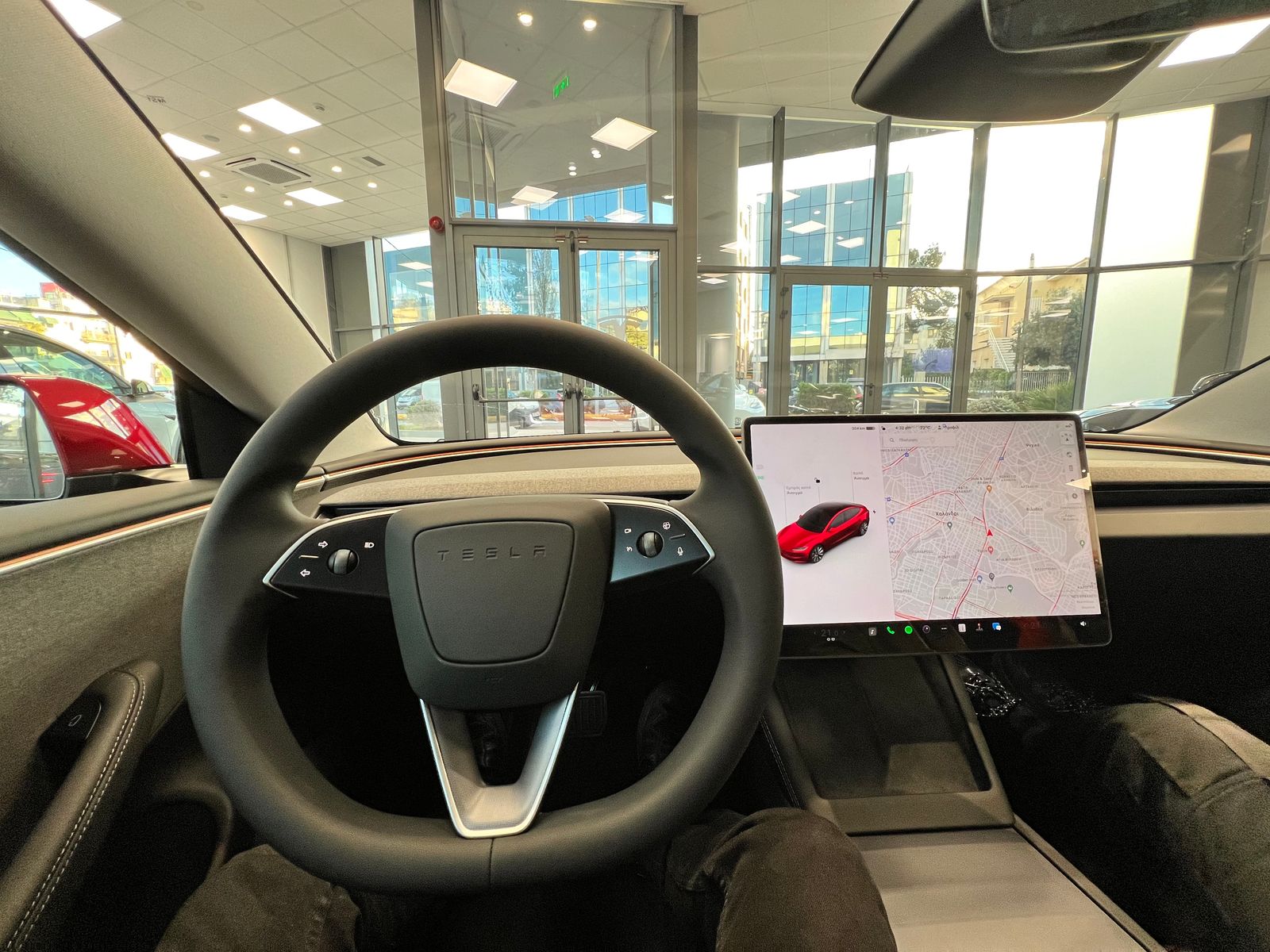 Venstrestyret Tesla Model 3 (Highland, 2023) — rat i venstre side og central touchskærm.